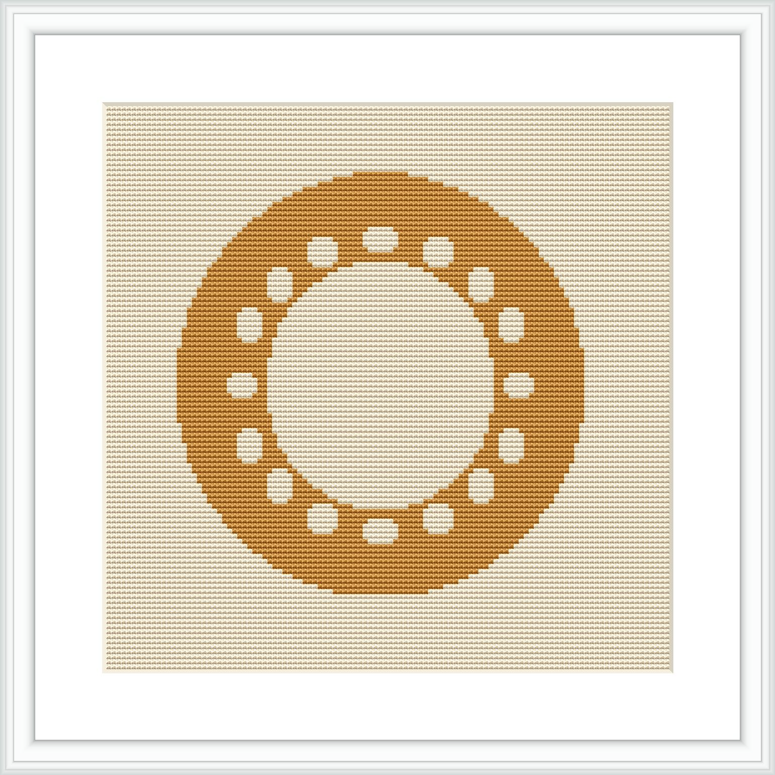 The image displays a framed cross stitch pattern hanging on a wall. The design depicts a centered circular motif made up of small geometric shapes, predominantly in shades of yellow, on an ecru or light beige aida cloth.