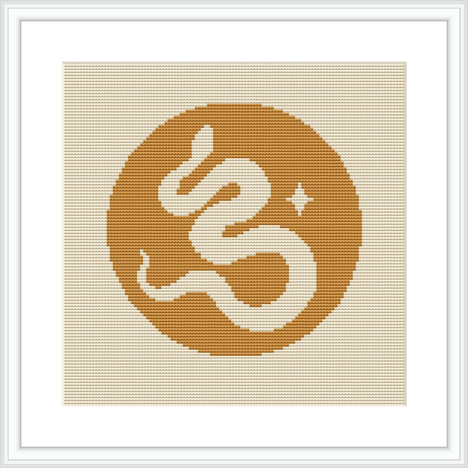 The image showcases a framed cross stitch pattern featuring a stylized monogram of the letter 'E' centered on a yellow circular background bordered by beige. Star-like and dot embellishments surround the letter.