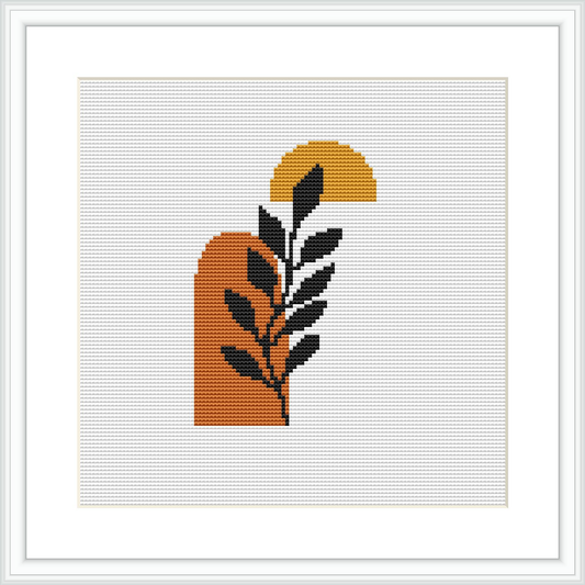 The image showcases a cross stitch pattern with an abstract interpretation of a botanical scene. It consists of a large semi-circular shape resembling the sun, a vertically oriented leaf motif, and colored primarily in burnt orange, with elements of mustard yellow, black, grey, and white.