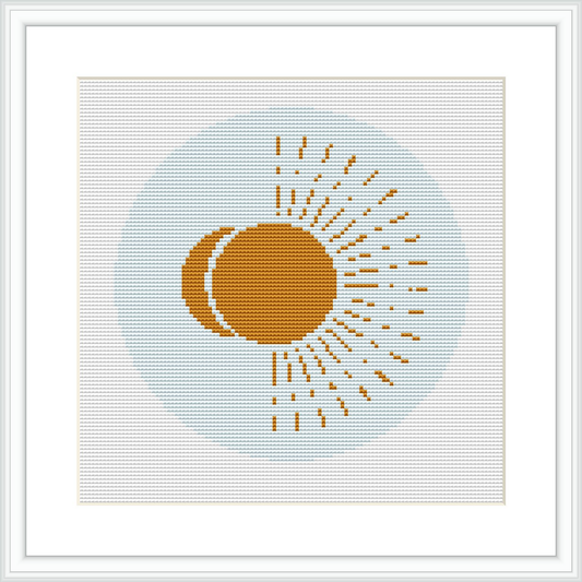 The cross stitch design features a stylized sun with a tan center, surrounded by golden yellow rays on a light blue background. The pattern is encompassed by a simple white border inside a white frame.