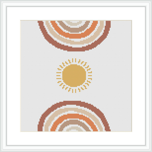 The image depicts a cross stitch pattern design featuring a stylized sun with rays extending outwards, set against a white background. The pattern is symmetrical, with multiple concentric circles creating a sense of radiating warmth.