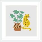 The image showcases a cross stitch pattern of a yellow and black spotted leopard sitting beside a potted plant with large green leaves. The plant is in a brown pot with decorative patterns.