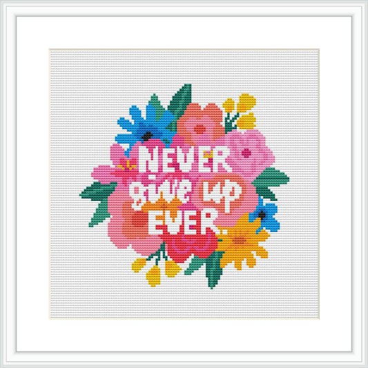 The image showcases a cross stitch pattern featuring the phrase 'NEVER GIVE UP EVER' in bold capital letters at the center, overlaying a colorful and vivid backdrop of flowers and leaves.