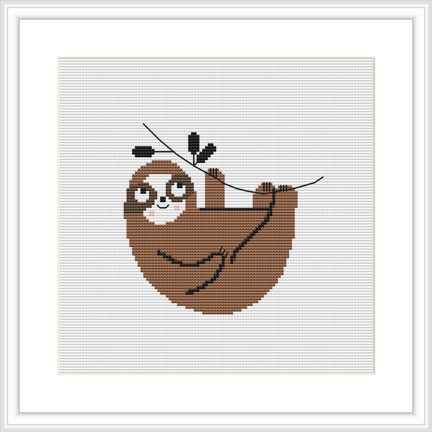 The image depicts a cross stitch pattern framed in white. It shows a brown sloth hanging from a branch, holding a stitching needle in its paws with a few leaves around it. The background is a plain white fabric.