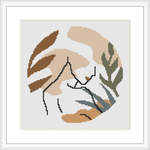 The image features an abstract representation of a human hand touching a sprig of leaves, within a square border. It's displayed as though it's stitched on a piece of fabric with a cross-stitch technique, and framed in a simple, modern frame.