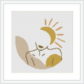The image displays a cross stitch pattern of a person in repose, seemingly sleeping or resting. They are enveloped by a crescent moon above and what appear to be stars. The piece is framed within a simple, elegant border.