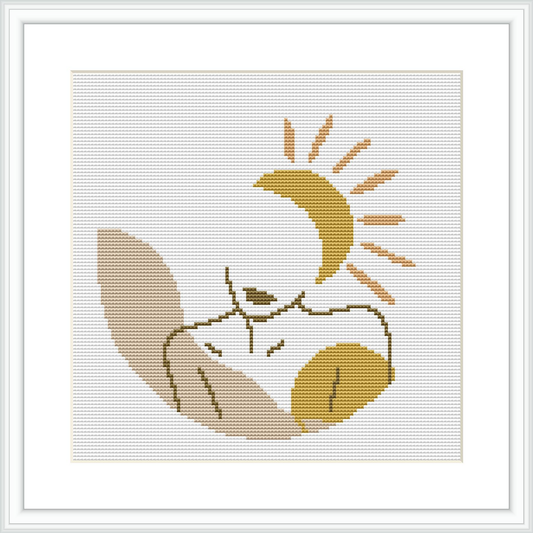 The image displays a cross stitch pattern of a person in repose, seemingly sleeping or resting. They are enveloped by a crescent moon above and what appear to be stars. The piece is framed within a simple, elegant border.