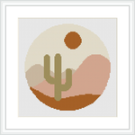 A framed cross stitch pattern showing a stylized desert scene with a cactus, rolling hills and a setting sun within a circle, all rendered in a pixel-like geometric style.