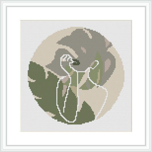 The image depicts a circular cross-stitch pattern framed in white, featuring the minimalist silhouette of a woman against a muted backgrounds with gradients of beige and olive.
