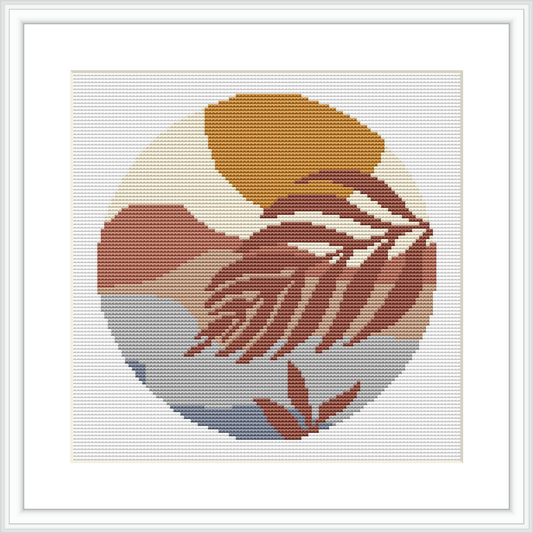 The image features a circular cross stitch pattern with the silhouette of a woman in profile. The pattern is designed with earthy colors, using shades of beige, brown, gray, and cream. It is framed within a white square background and encapsulated by a simple border.