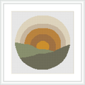 The image shows a cross stitch design featuring a stylized, simplistic sunrise with a yellow center, an orange ring around it, and a larger beige ring enclosing the orange. The bottom half depicts two green hills in a darker tone in front and a lighter tone in the back under a circular backdrop.