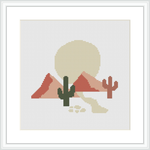 The image depicts a cross stitch pattern featuring a desert scene with two cacti in the forefront, and mountains with a large setting sun in the background, all framed within a white border.