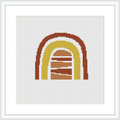 The image features a cross stitch pattern of a simplified, abstract depiction of a house or cabin, presented in gradient shades of warm colors, contained within a plain white frame against a white background.
