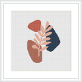 The image features a cross stitch pattern with two abstract shapes resembling stylized vessels or pots, one in terracotta and another in navy blue, overlaid with a branch in a pastel peach color against a cream background, all within a framed white border on a grey surface.