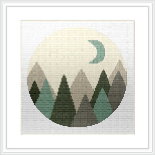 This cross stitch pattern features a circular design with geometric shapes forming a mountain range in the foreground and a crescent moon in the background.