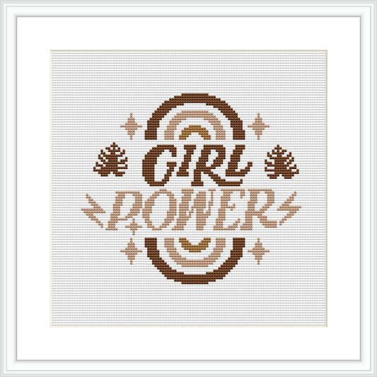The image showcases a framed cross stitch sampler with the words 'GIRL POWER' in a bold font at the center, surrounded by ornamental floral elements and accents in shades of brown.