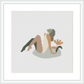 The image displays a framed cross-stitch pattern featuring an abstract representation of a woman sitting in a relaxed pose with a leaf-like pattern in the background.