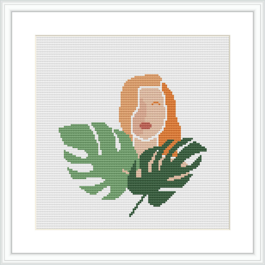 The image contains a stylized depiction of a woman's face and upper torso accompanied by tropical leaves. She appears to be overlaying or emerging from the foliage. The pattern is within a square frame, with a white background.