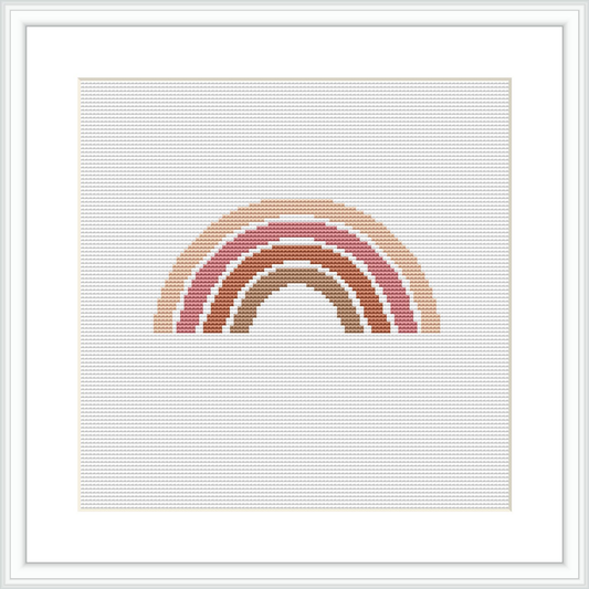 The image displays a framed cross stitch pattern with a simple, abstract design of a rainbow composed of horizontal arches. The arches are in shades of pink, coral, and cream.