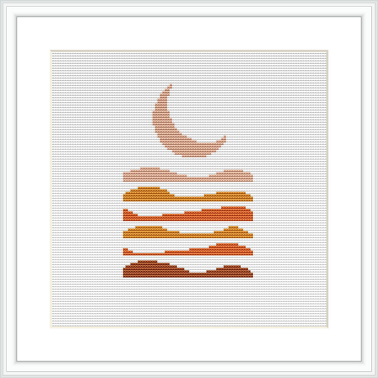 The image features a stylized cross stitch pattern of geometric mountains stacked under a crescent moon, set against a plain white background within a framed presentation.