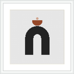 The image showcases a framed cross stitch pattern featuring a black arch with a terracotta pot resting on top. The background is white, and the design is centered within the frame.
