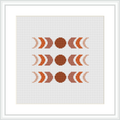 The image shows an abstract cross-stitch pattern comprised of circular and crescent shapes in a symmetrical arrangement. The design uses earthy brown and beige tones, centralized on a squared canvas, framed by a simple white border.