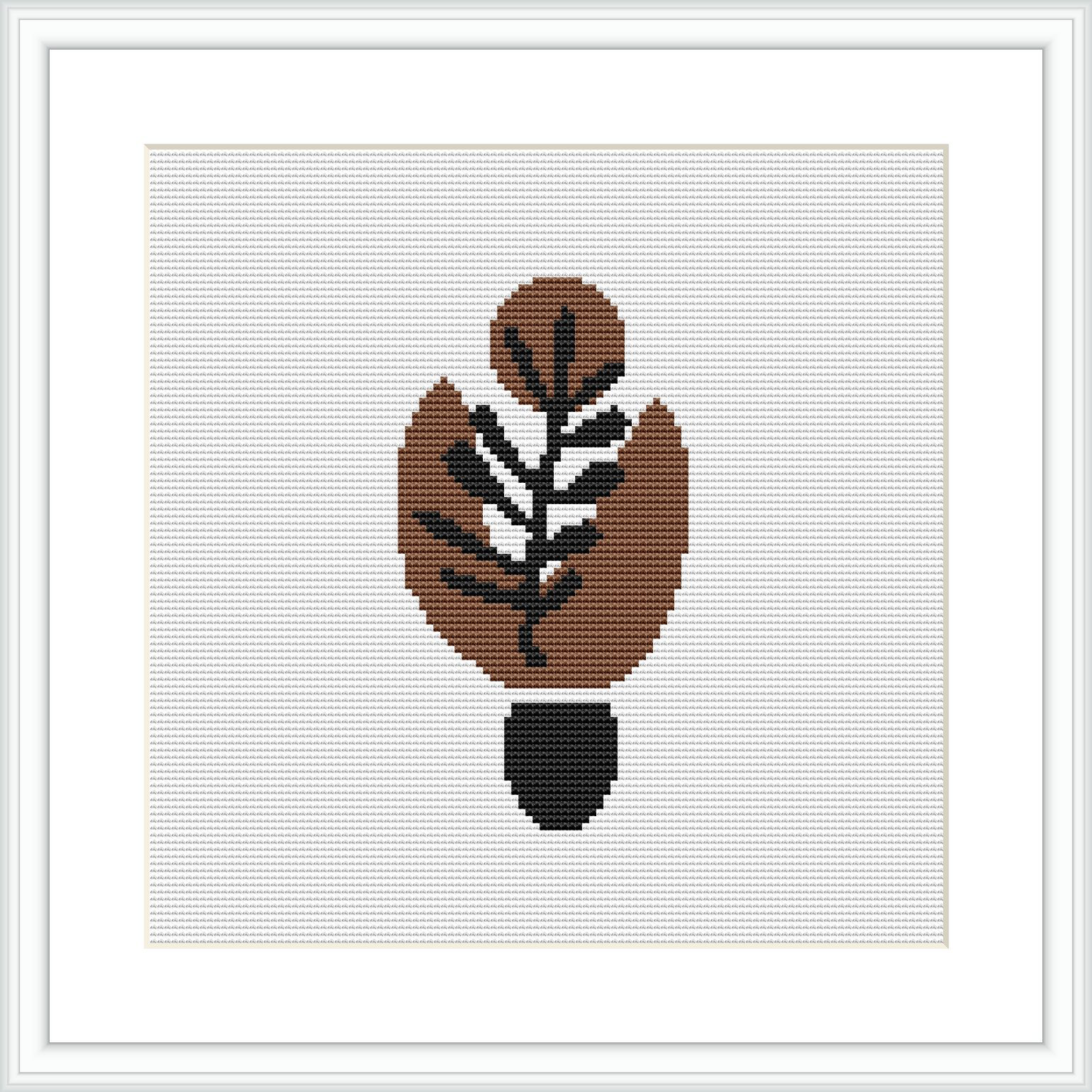 The image shows a framed cross stitch pattern of an abstract leaf design, predominantly in warm brown tones with a black outline, centered on a white canvas background.