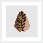 This cross stitch pattern depicts an abstract interpretation of an autumn leaf. The leaf is rendered with pixelated effect, using a warm color palette on a plain, white background.