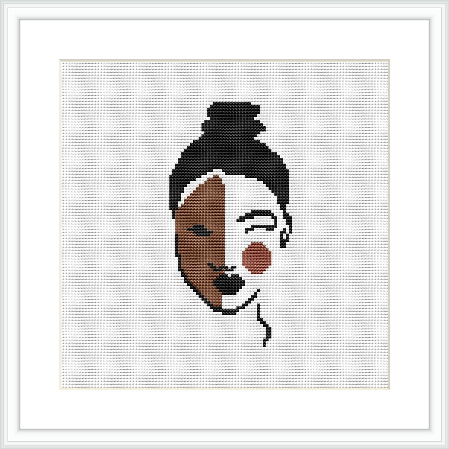 The image displays a framed cross-stitch pattern featuring an abstract design of a woman's face on a white canvas. The face is composed of geometric shapes with varying shades and colors.