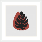 A framed cross stitch pattern depicts an abstract design resembling a leaf with a combination of crimson and black, highlighted with pale pink, against a white background.