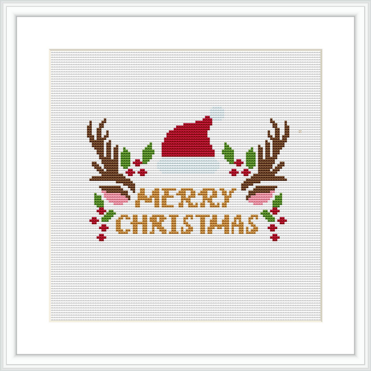 The scene shows a cross stitch pattern with 'Merry Christmas' text in the center, flanked by two reindeer antlers, a Santa hat resting on the 'M' and holly berries & leaves interspersed.