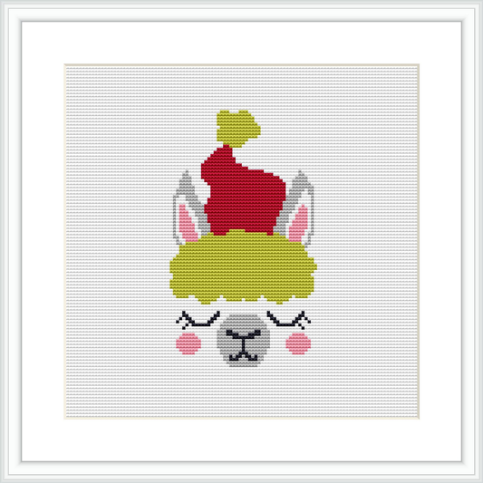 The image displays a framed cross stitch pattern featuring the stylized face of a llama with closed eyes and rosy cheeks, wearing a green and red Christmas hat against a plain white background.