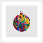 The image depicts a framed cross stitch pattern of a Christmas ornament. The design displays a spherical shape filled with an array of geometric patterns in various colors. It is centered on a white background within a square frame.