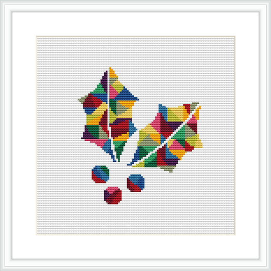 The image displays a cross-stitch pattern of geometric shapes forming abstract representations of Christmas leaves and berries, framed and ready for display. The shapes are assorted in colors and displayed on a white background within a square frame.