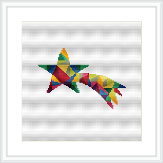 The image showcases a framed cross stitch pattern depicting a multi-colored geometric star. The design is presented on a white fabric background, central within a square frame.