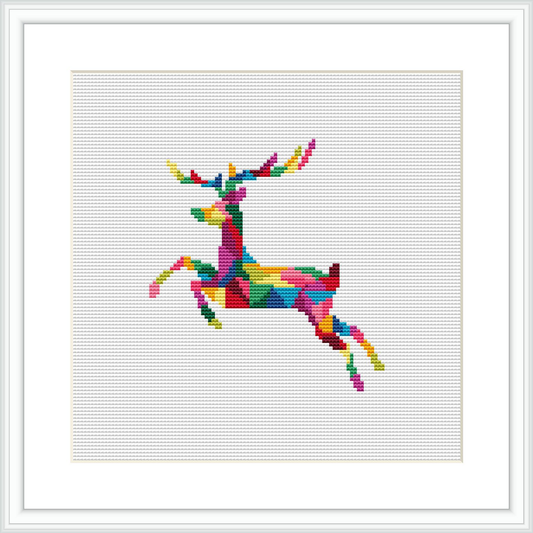 The image portrays a framed cross stitch pattern of a geometric reindeer design, predominantly composed of multicolored squares, bordered by a simple white frame and against a white background.