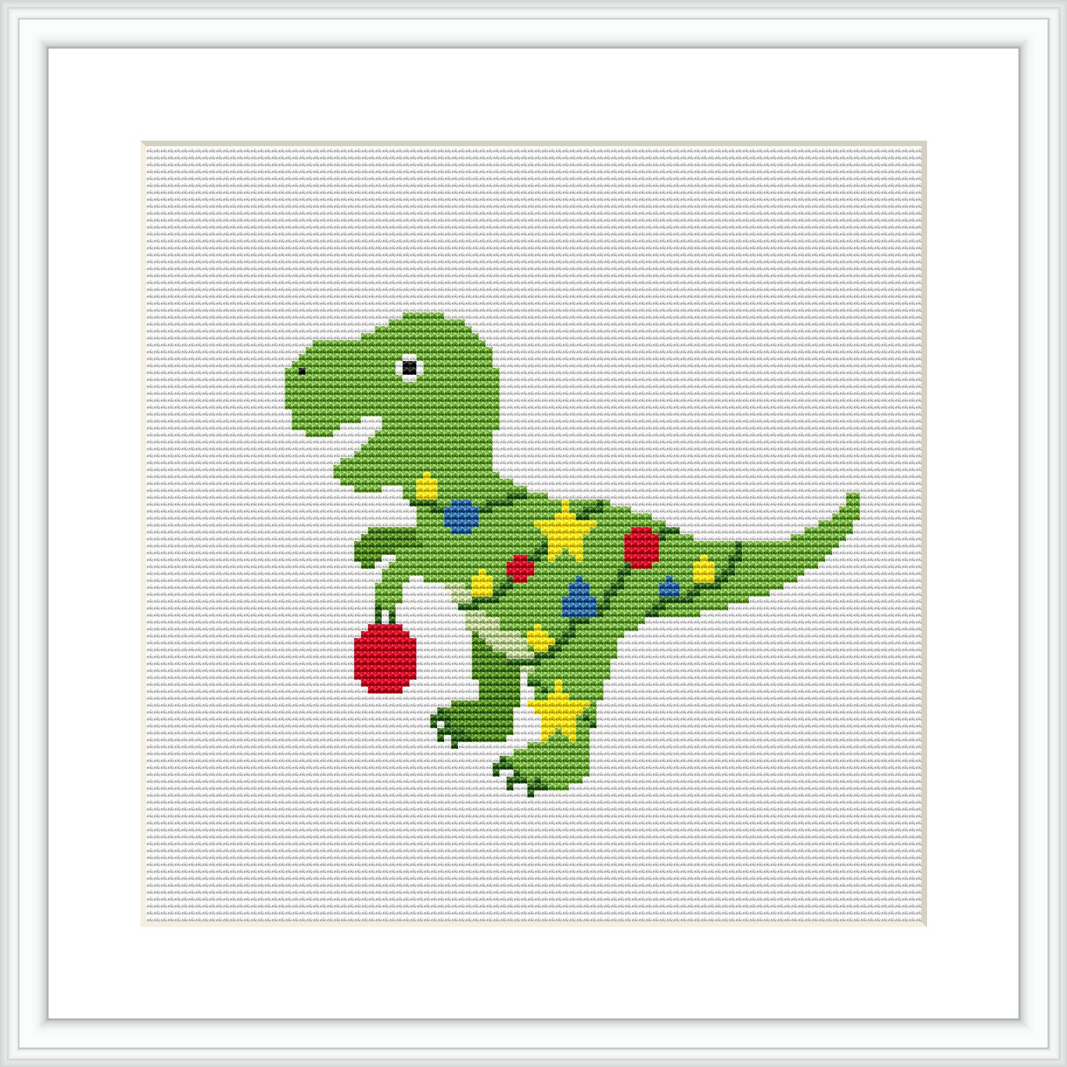 The image features a cross stitch pattern of a green dinosaur with red and blue ornaments on its back and a red Christmas bauble hanging from its mouth. The design is framed by a simple white border.