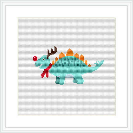 The image depicts a cross-stitch pattern of a green dinosaur with a red scarf and what appears to be reindeer antlers, embellished with decorative Christmas-themed patterns.