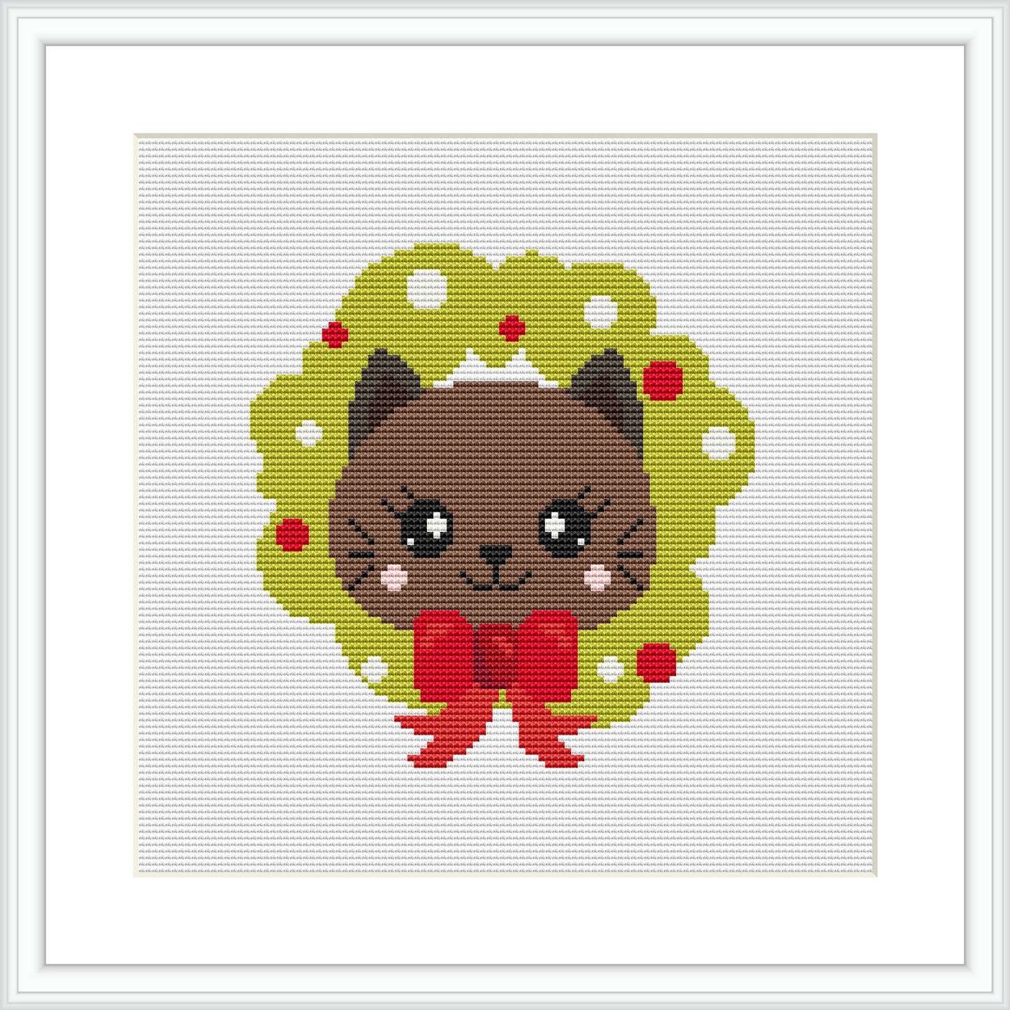 This image features a finished cross stitch pattern with a cute cat centered in the frame. The cat sits within a green holly wreath decorated with red berries. It wears a large red bow around its neck and is framed against a white background, all within a visible hoop or frame.