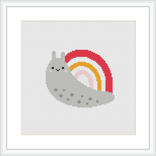 A framed cross stitch pattern of a gray snail with a pink and red spiraled shell, featuring a small rainbow motif, against a white background.