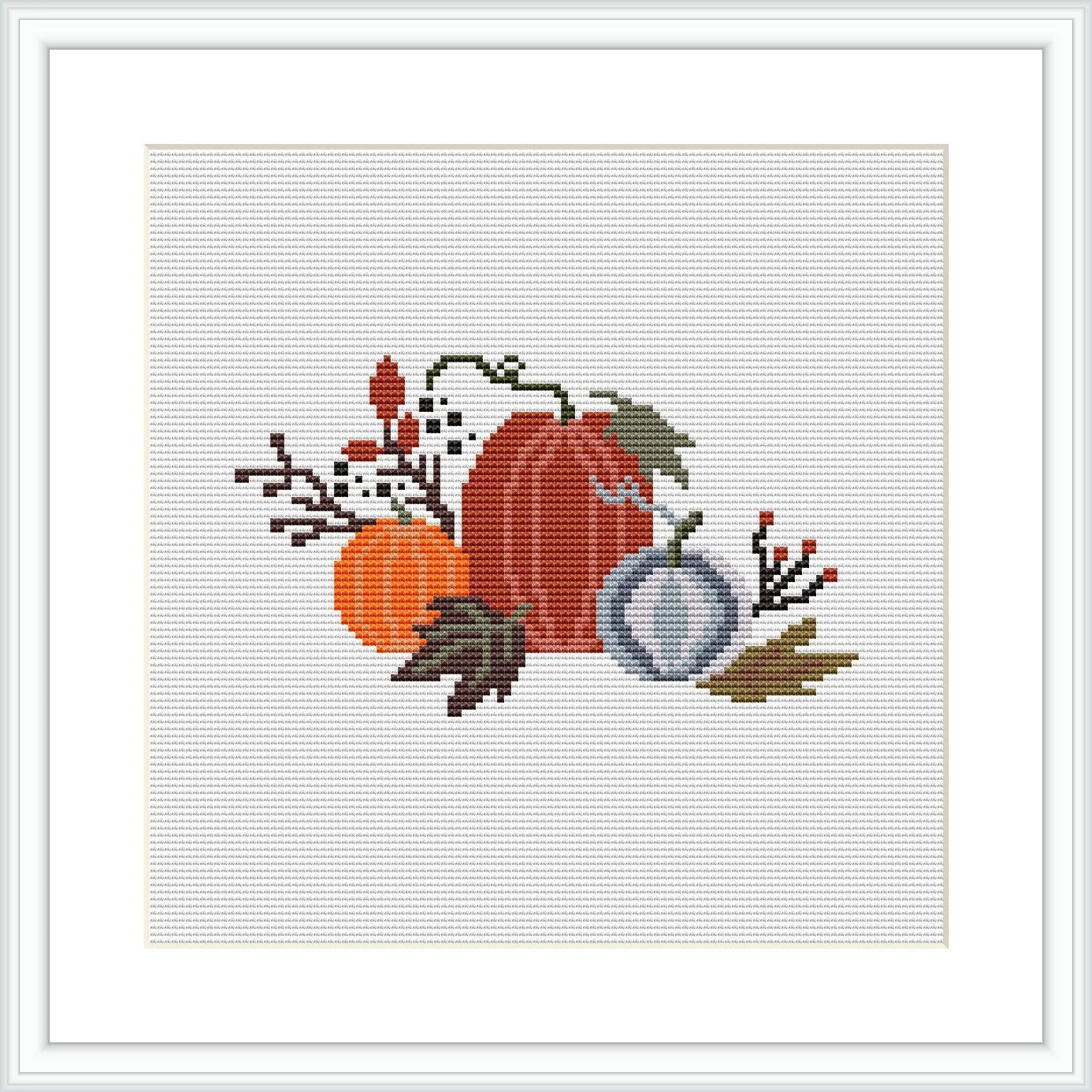 The image shows a cross stitch pattern featuring two pumpkins in shades of orange and gray, surrounded by autumn leaves, berries, and twigs on a white canvas framed in a simple square black frame.