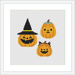 The image features three smiling jack-o'-lanterns placed closely together. The top pumpkin wears a black witch hat, while the others are without accessories.