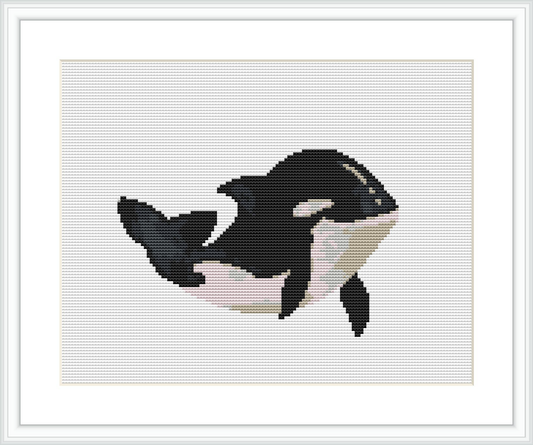 The image depicts a cross stitch pattern of an orca or killer whale, centered on a white canvas. The orca is oriented diagonally, with its dorsal fin to the top left and its tail to the bottom right.