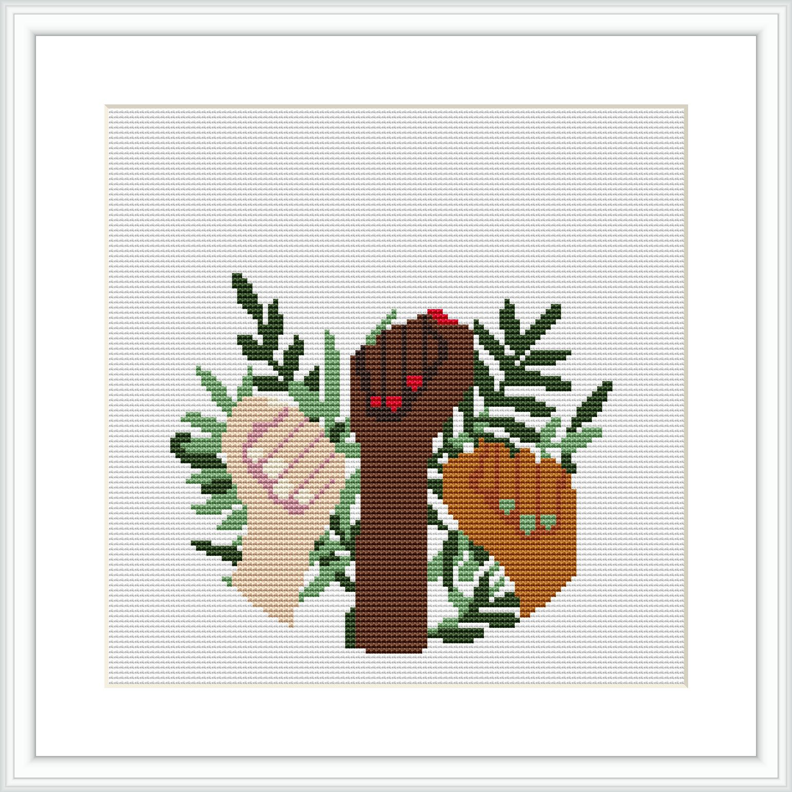 The image depicts a cross stitch pattern showcasing an arrangement of various leaf shapes in different shades of green. A stylized branch in brown extends through the design with a red and a beige decorative heart, each with small accent details.