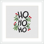 The image displays a cross stitch pattern featuring the words 'HO HO HO' in large, bold, black letters, with sprigs of holly and red berries scattered around and between the letters on a white background, enclosed within a frame.