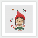 The image depicts a framed cross stitch pattern of an elf girl surrounded by festive elements such as holly leaves and a star, against a white background.