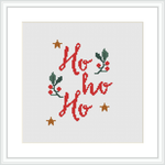 The image features a cross stitch pattern with the words 'Ho ho ho' in red, adorned with green holly leaves and berries, and accented with golden stars, all framed against a white background within a simple square frame.