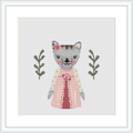 The image displays a cross stitch pattern design of a grey and white cat wearing a pink dress with a white apron. The cat is flanked by two olive green branches with leaves, set against a plain white background.