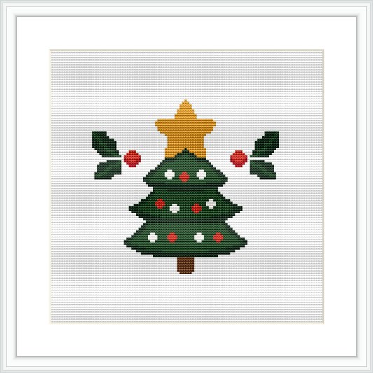 The image showcases a completed cross stitch pattern framed against a white background. The pattern features a traditional Christmas tree, decorated with red ornaments and a gold star on top, flanked by two branches of holly with red berries.