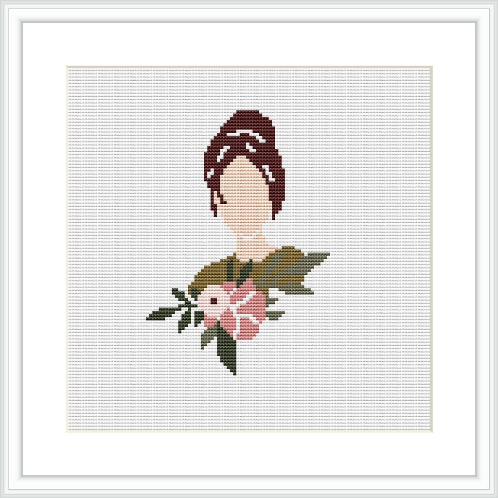 The image displays a framed cross stitch pattern depicting the upper torso of a stylized woman adorned with a floral arrangement. The pattern has a white background and is mounted within a simple, elegant frame.